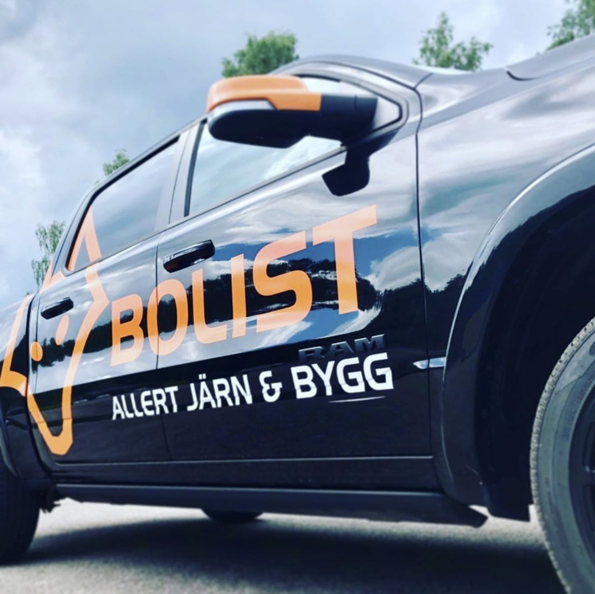 Mörkblå pickup med orange dekor för Bolist och Allert Järn och Bygg