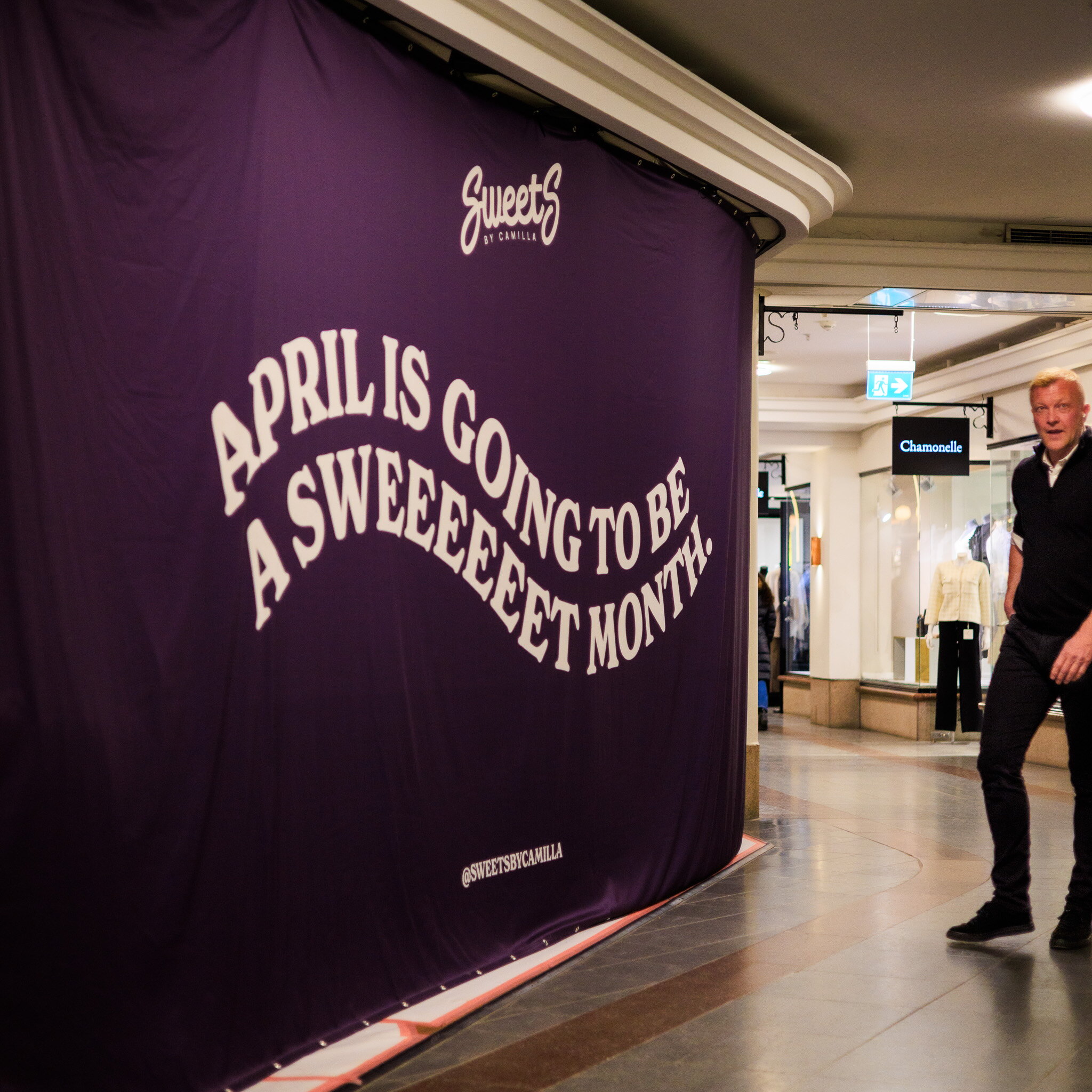 Stor lila Sweet's-vepa med vit text uppspänd i ett gångstråk