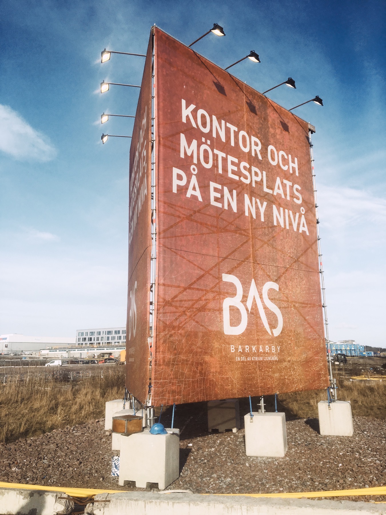 Stor byggvepa med egen belysning uppspänd på fristående ställning vid ett byggområde i Barkarby