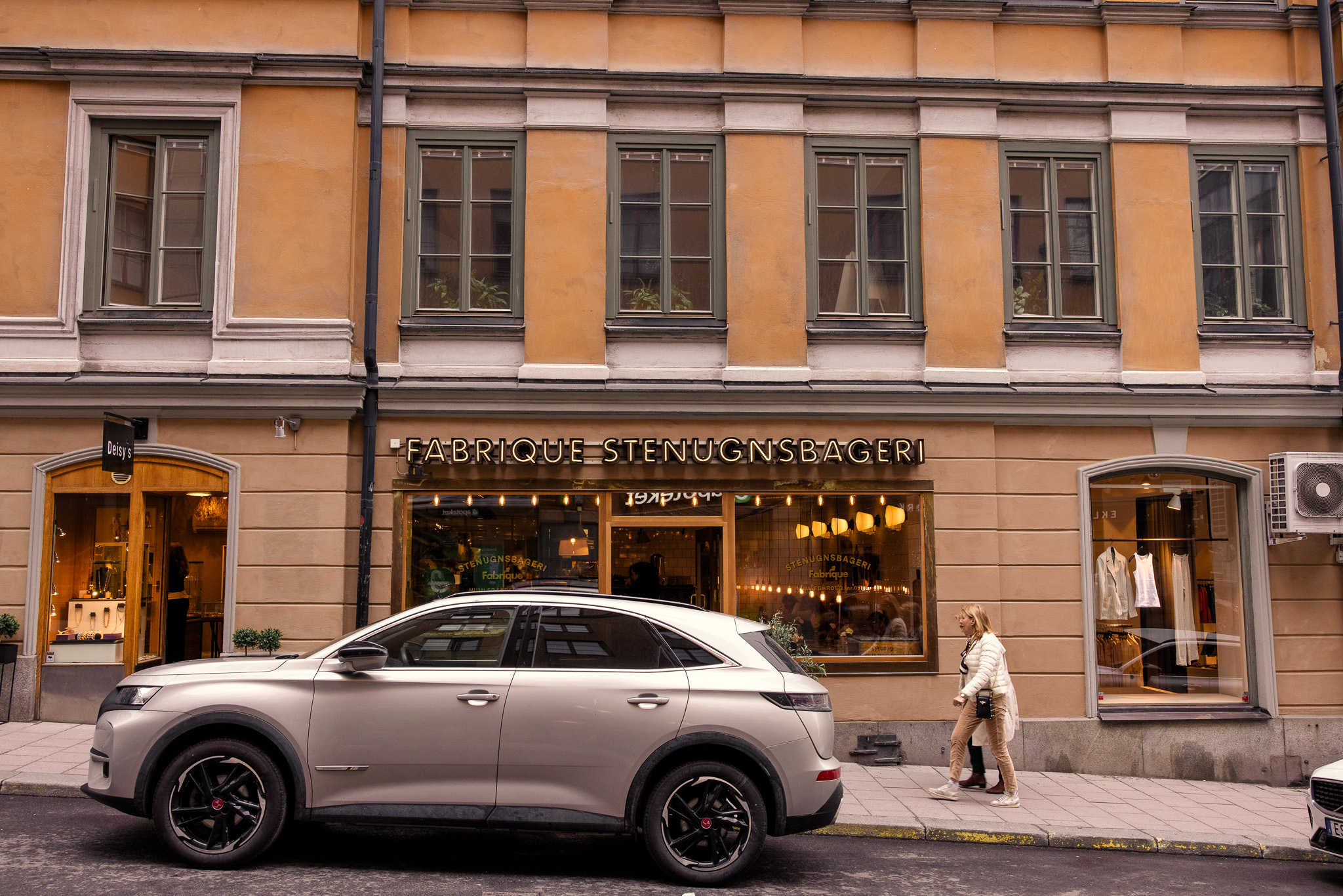 Fabrique Stenugnsbageri i belysta bokstäver över skyltfönstren på Humlegårdsgatan, guldtext på glasen