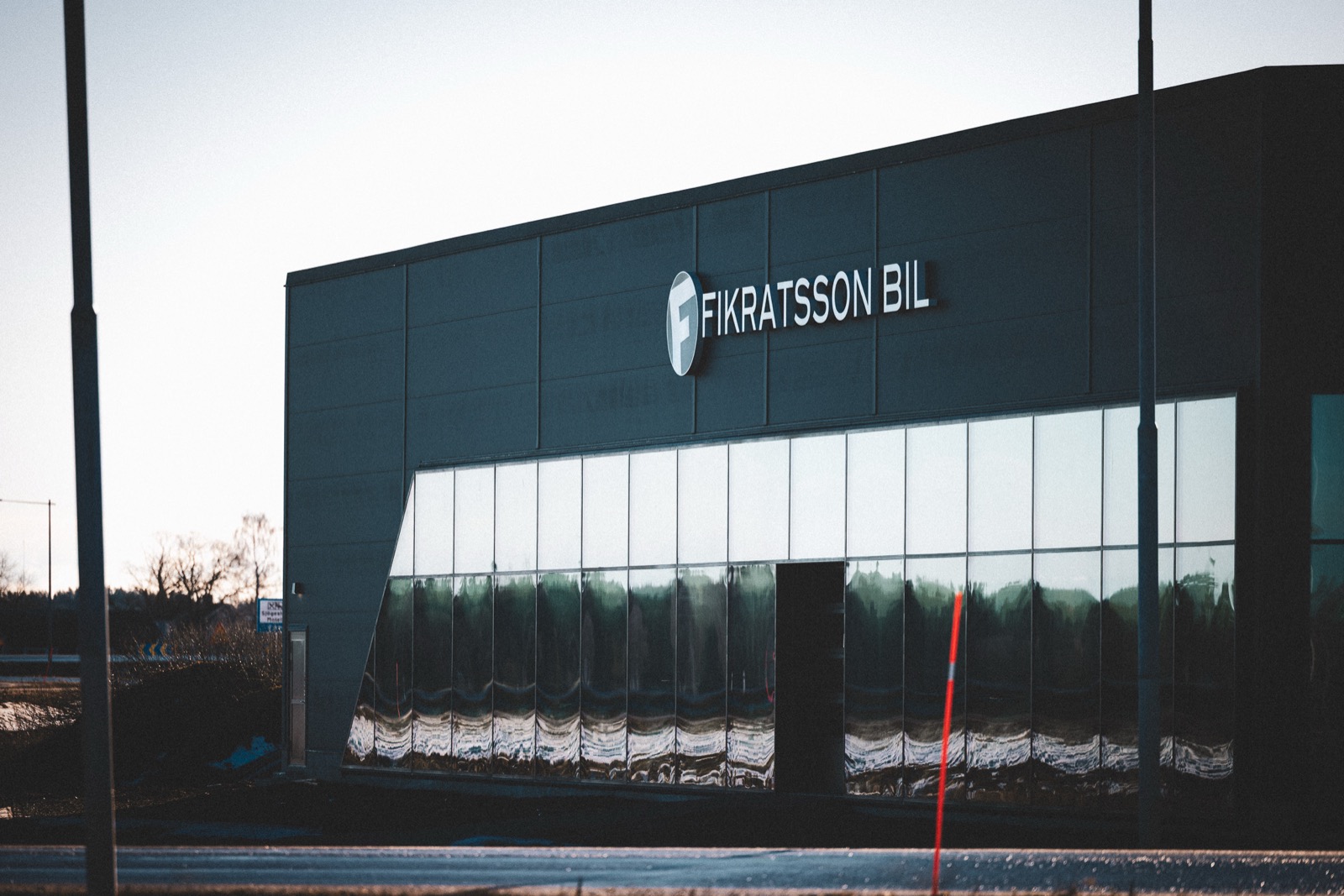 Fikratsson Bils anläggning med friskurna bokstäver och logotypskylt på mörk fasad