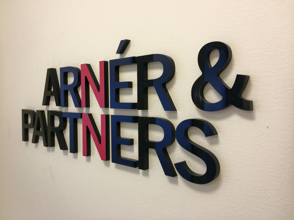 Fristående frigolitbokstäver som bildar företagsnamnet Arner och Partners på en kontorsvägg