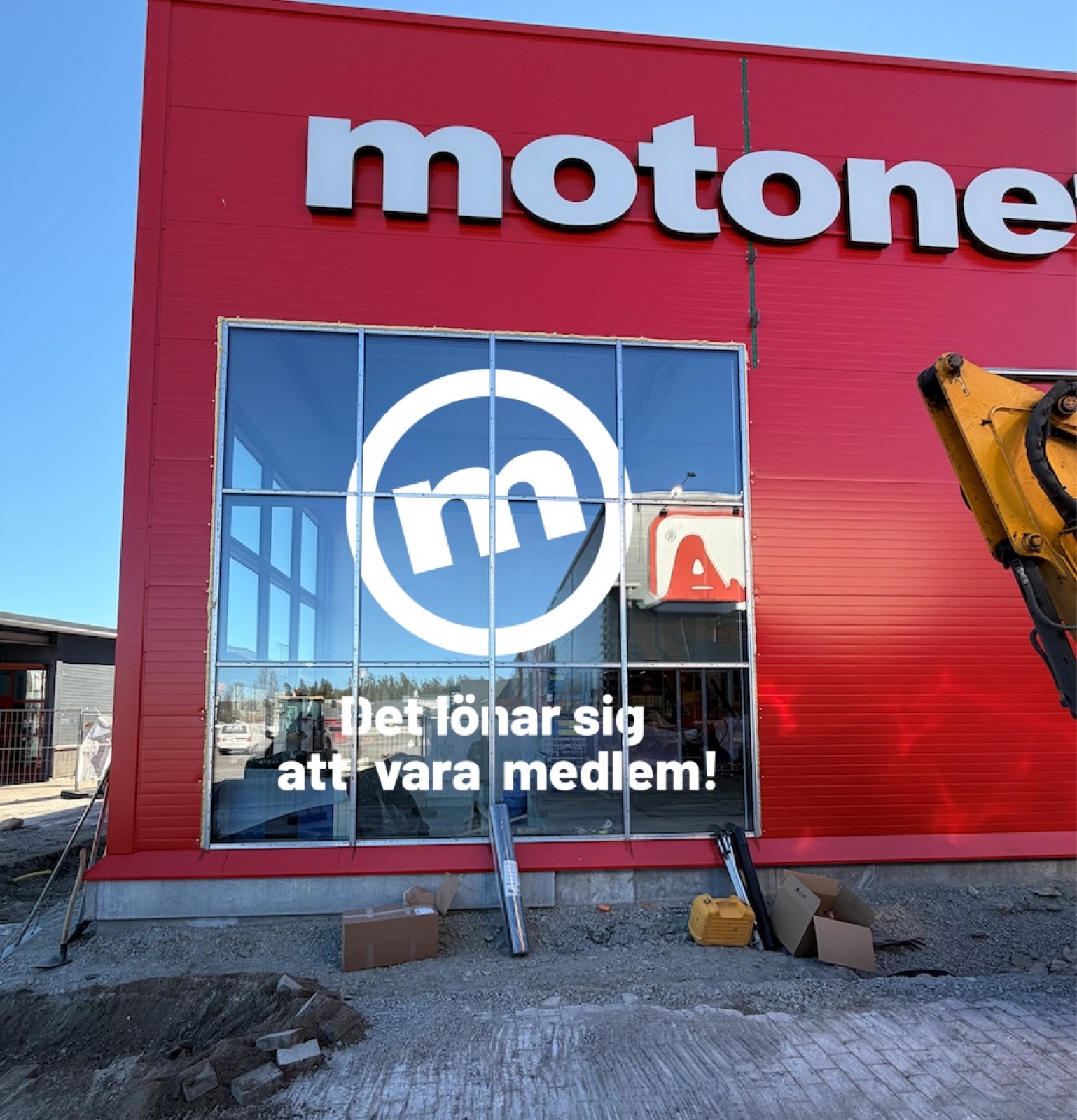 Motonet-varuhus med vita fasadbokstäver på röd fasad och fönsterdekor i skyltfönstret