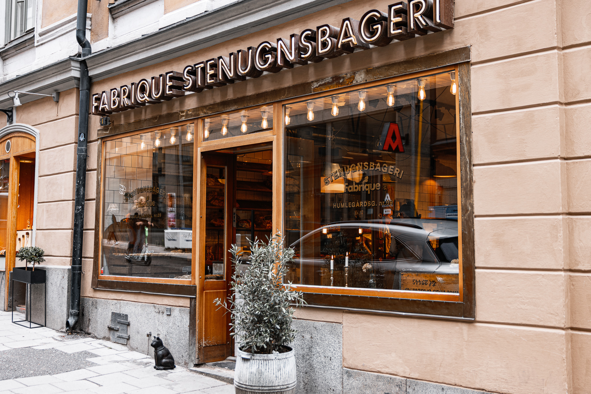 Klassisk neonskylt med texten Fabrique Stenugnsbageri på fasad i Stockholm