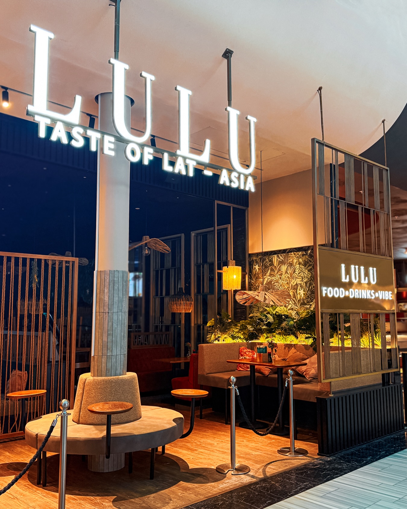 Belysta LULU-bokstäver och logotypskylt i restaurangens interiör
